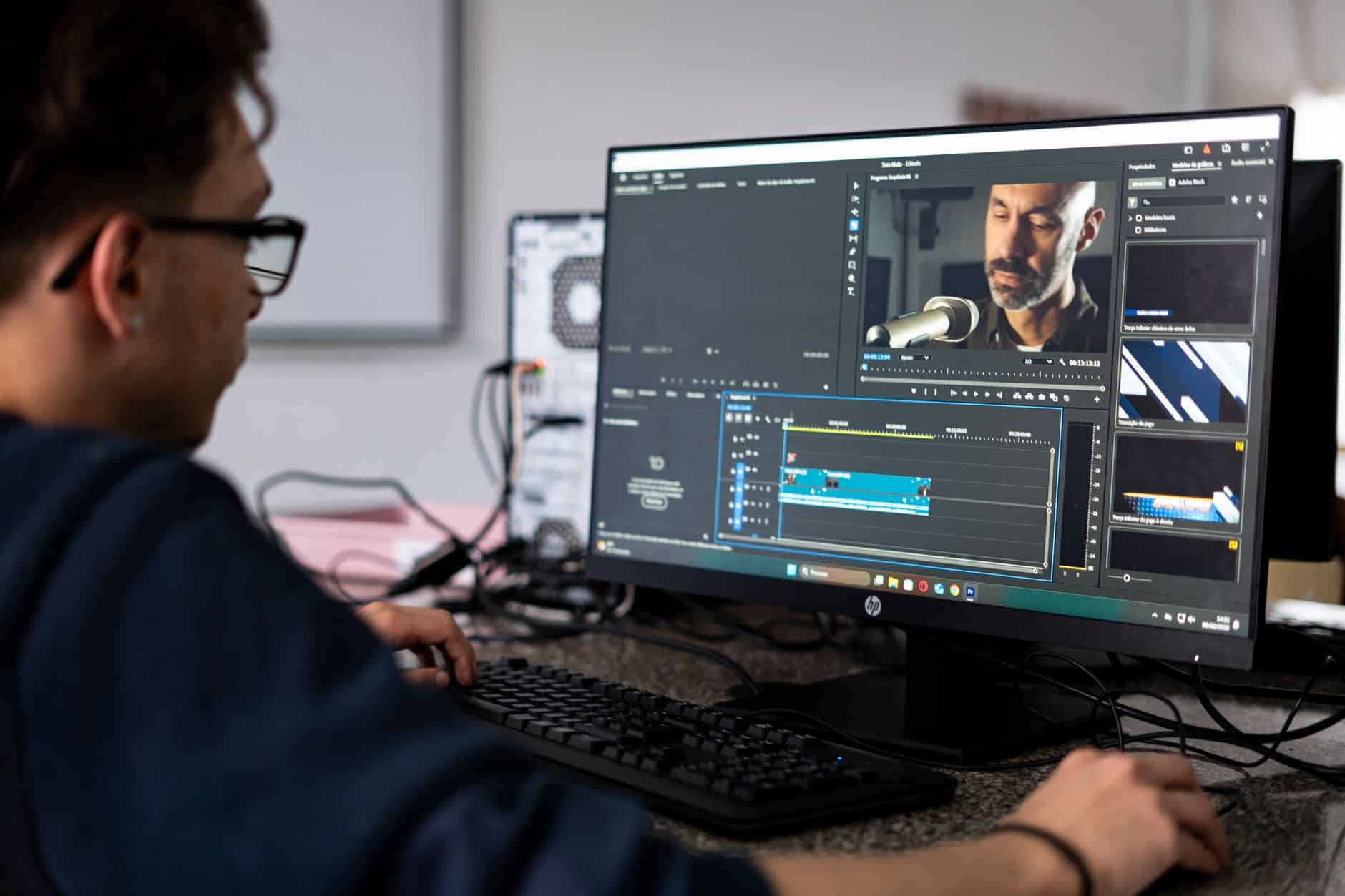 Monteur vidéo au travail sur une station de montage multi-écrans