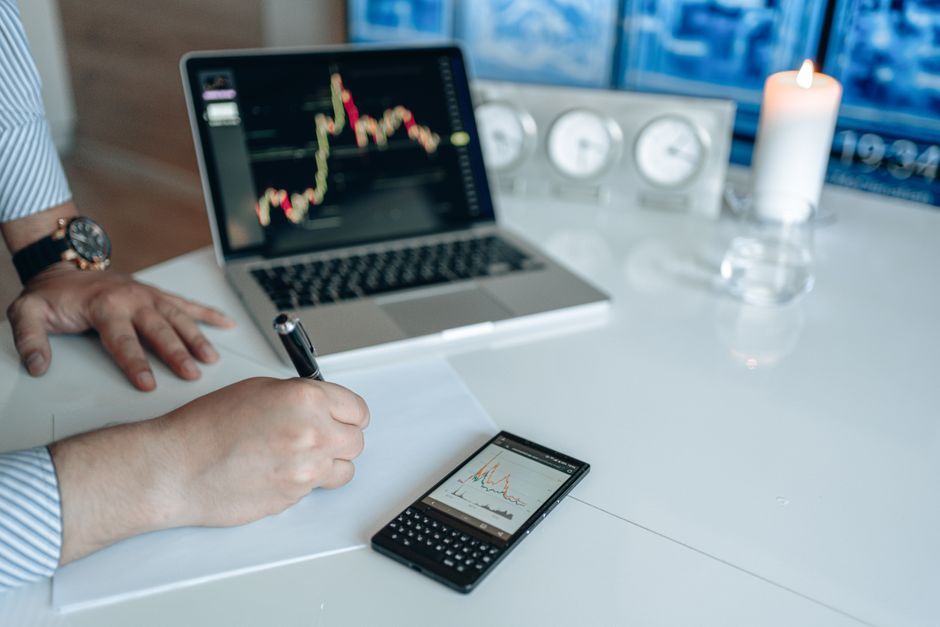 Analyste financier travaillant avec un ordinateur portable affichant des graphiques de tendance